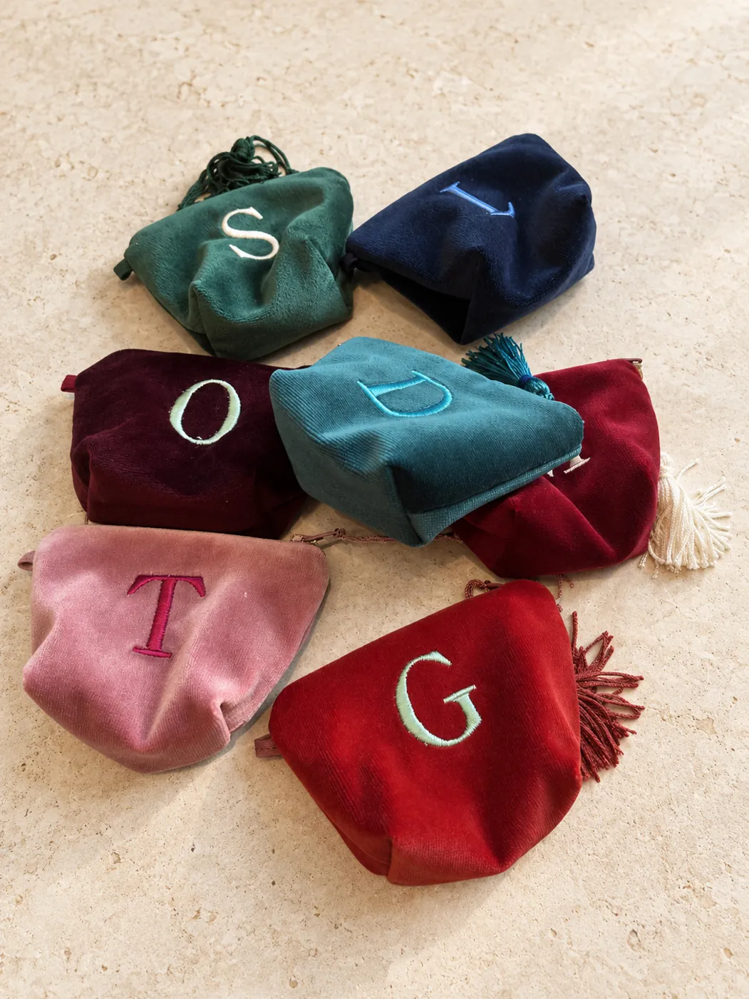 Mini velvet pouches in assorted colours, each with an embroidered initial